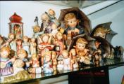 a lot of hummel figurines in the show case